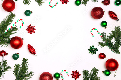 Christmas frame made of d decorations and fir branches on a white background.