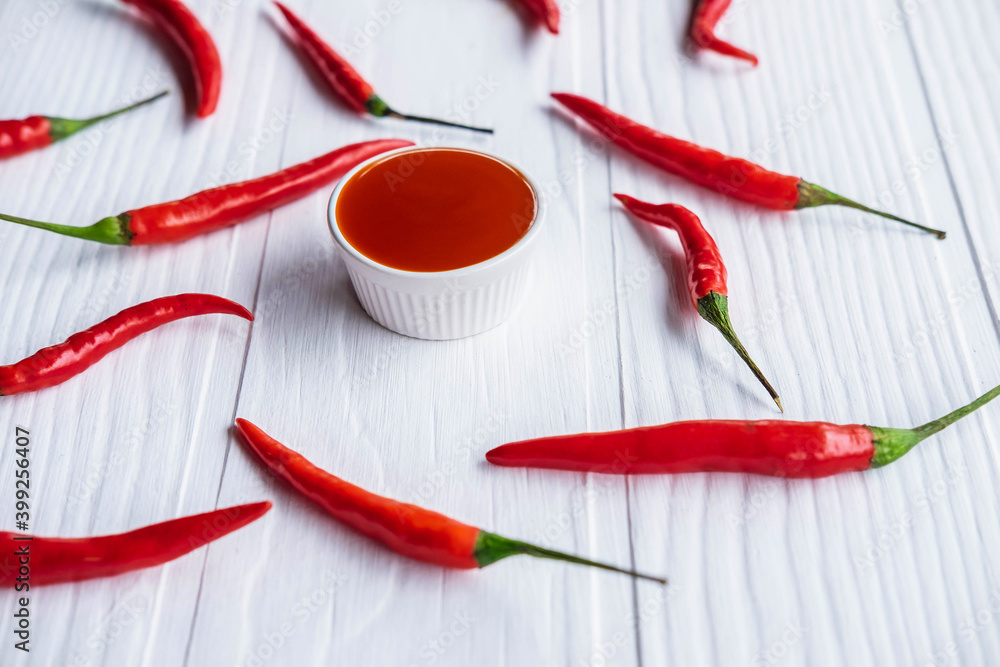 .Fresh chillies with hot chili sauce on the table .Fresh chillies with hot chili sauce on the table