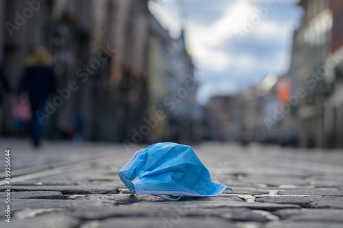 Konstfotografi Discarded face mask lying in a city street
