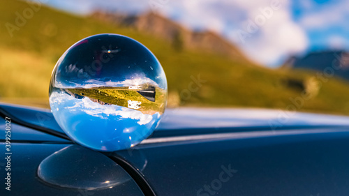 Crystal ball alpine landscape shot with reflections on a car roof at Hochgurgl, Oetztal, Tyrol, Austria