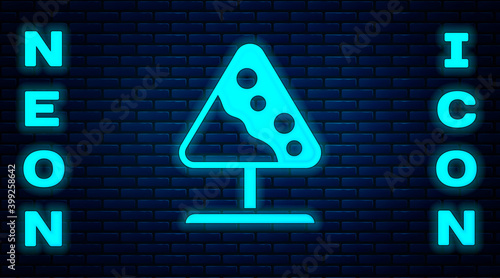 Glowing neon Road sign avalanches icon isolated on brick wall background. Snowslide or snowslip rapid flow of snow down a sloping surface. Vector.