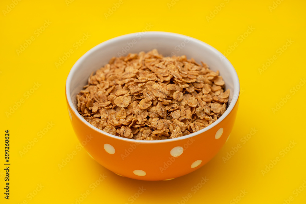 flakes wheat in the bowl on yellow background flakes wheat in the bowl on yellow background