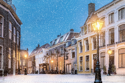 Winter view with snowfall of houses on the Pieterskerkhof in the old Dutch city center of Leiden photo