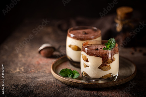 Foto Traditional Italian dessert tiramisu in a glass on on dark background