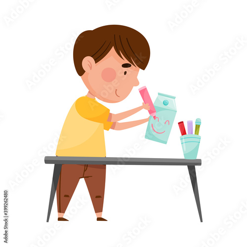 Little Boy Drawing Smiley on Used Carton Package Vector Illustration