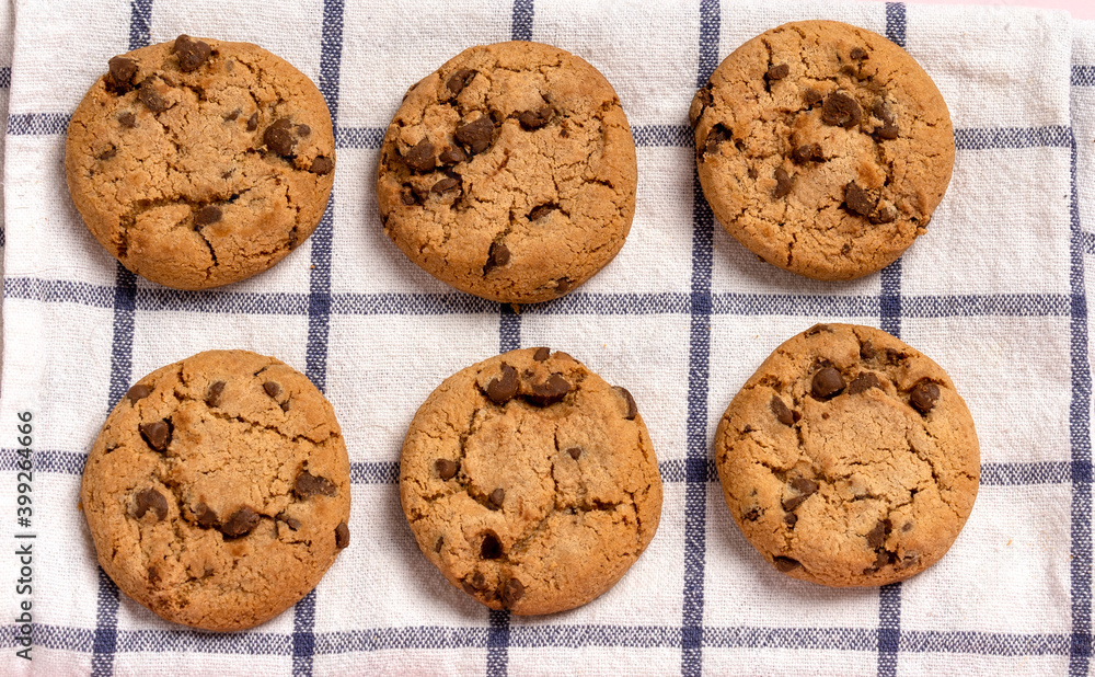 Oatmeal chocolate chip cookies on a checkered towel on a pastel pink background with space for text Oatmeal chocolate chip cookies on a checkered towel on a pastel pink background with space for text