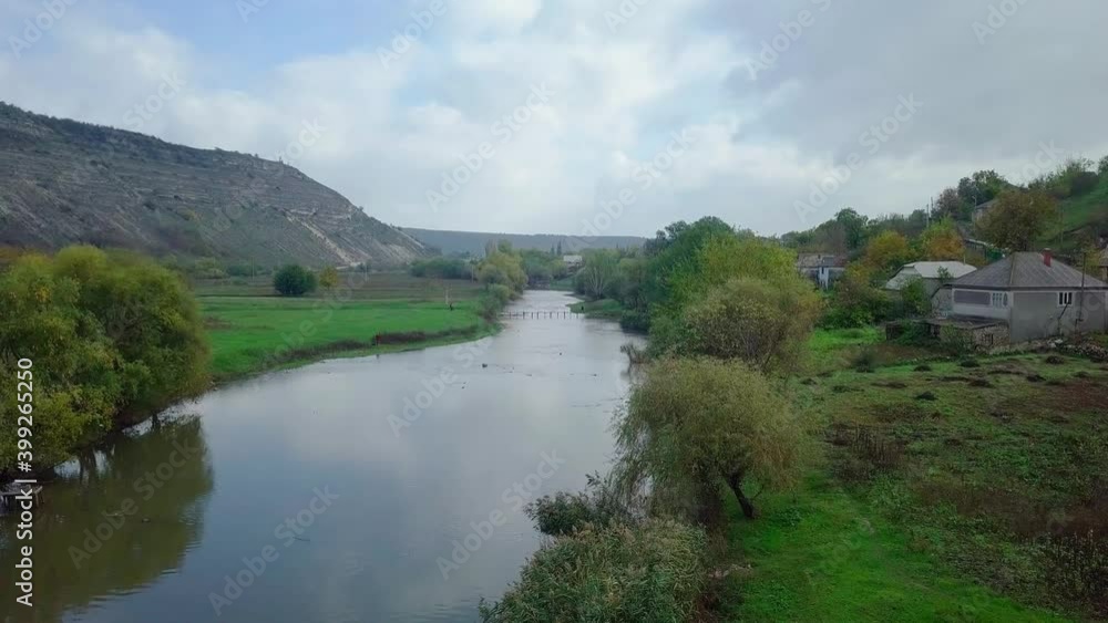Drone flight over the river and smal moldavian village in autumn landscape. Moldova republic of. Drone flight over the river and smal moldavian village in autumn landscape. Moldova republic of.