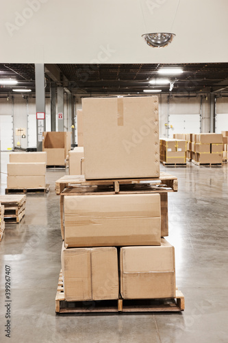 Cardboard boxes piled on pallets in warehouse. photo