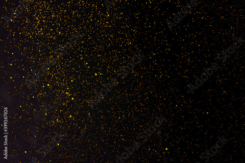 Golden falling glitter on the black background, festive overlay