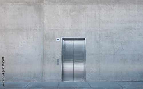 Metal elevator doors in a concrete wall.