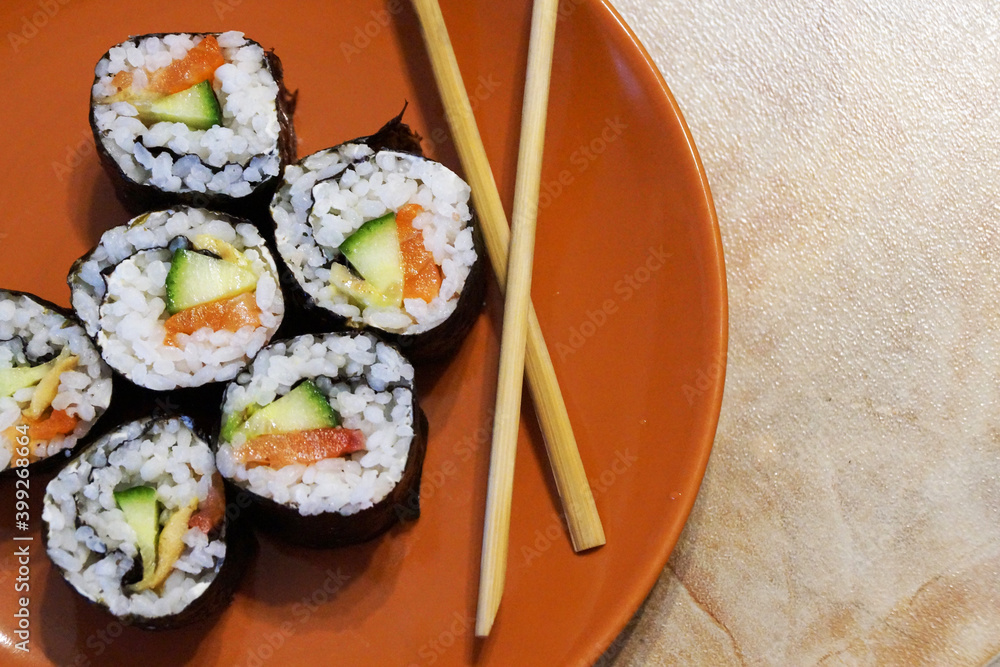 Japanese sushi and wooden sticks on a plate Japanese sushi and wooden sticks on a plate