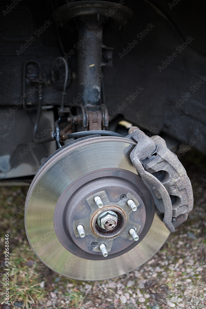Old steel ventilated brake disk with fixed calliper and brake pads are ready for removing, front wheel Old steel ventilated brake disk with fixed calliper and brake pads are ready for removing, front wheel