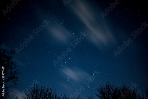 View of stars in a clear night sky with motion in clouds moving acroos the sky above © tommoh29