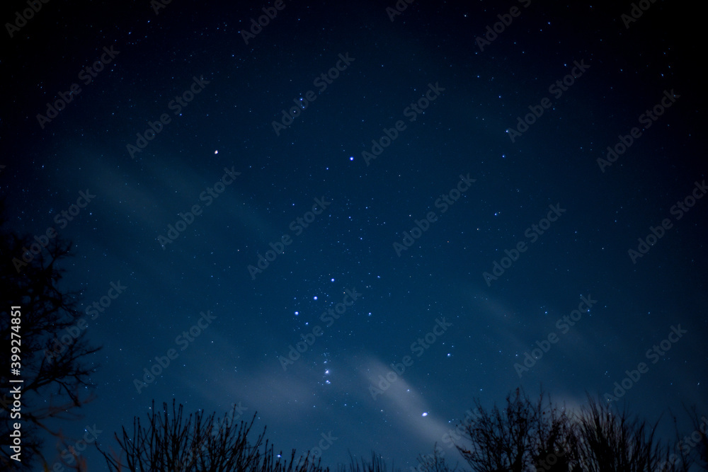 View of stars in a clear night sky with motion in clouds moving acroos the sky above View of stars in a clear night sky with motion in clouds moving acroos the sky above