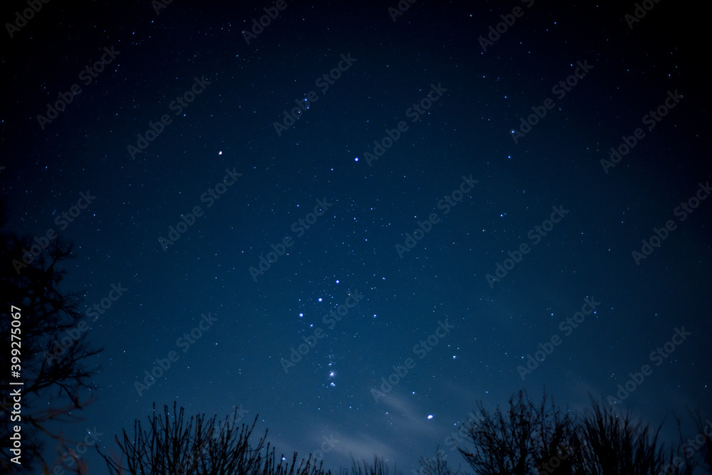 Fototapeta premium View of stars in a clear night sky with motion in clouds moving acroos the sky above