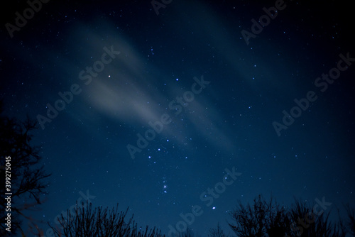 View of stars in a clear night sky with motion in clouds moving acroos the sky above © tommoh29