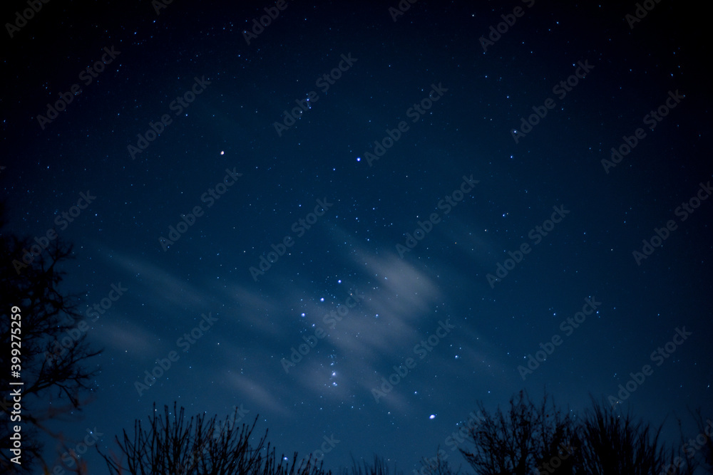 View of stars in a clear night sky with motion in clouds moving acroos the sky above View of stars in a clear night sky with motion in clouds moving acroos the sky above