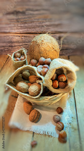 w koszyczku na stole dębowym w otoczeniu orzechów laskowych i włoskich oraz orzechów kokosowych