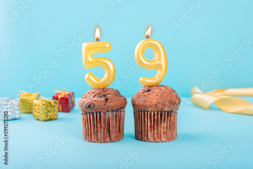 59 Number gold candle on a cupcake against a pastel blue background fifty ninth year celebration photo