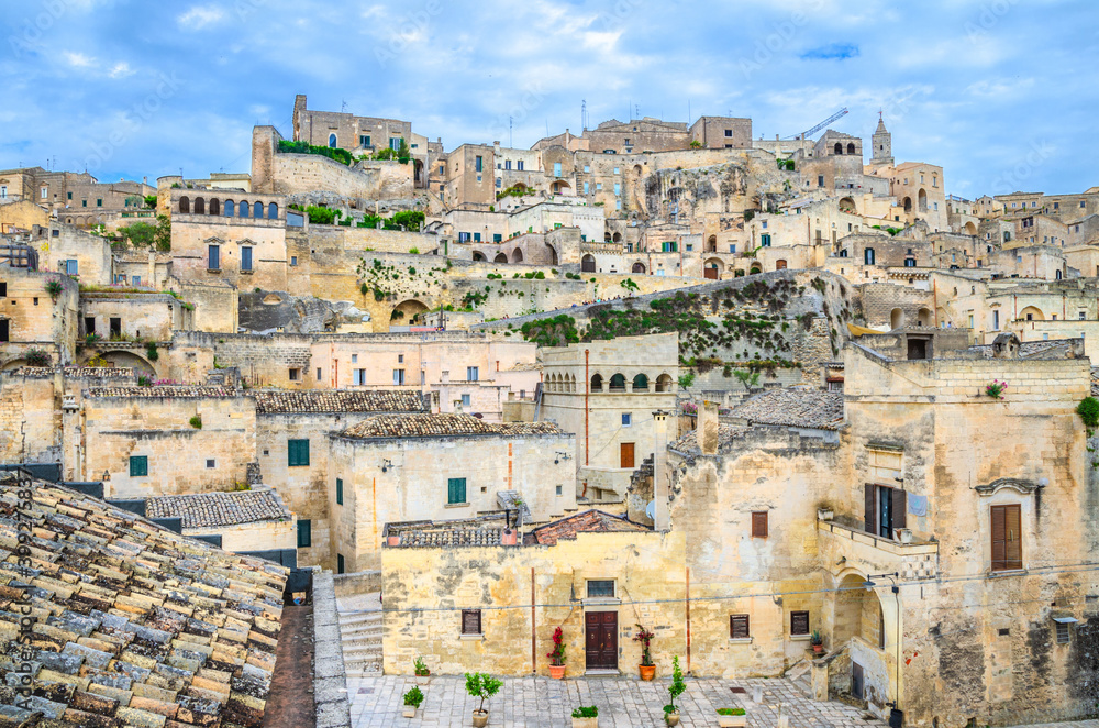 Sassi di Matera, historical centre Sasso Caveoso of old ancient town with rock cave houses, blue sky and white clouds, UNESCO World Heritage, Basilicata, Southern Italy