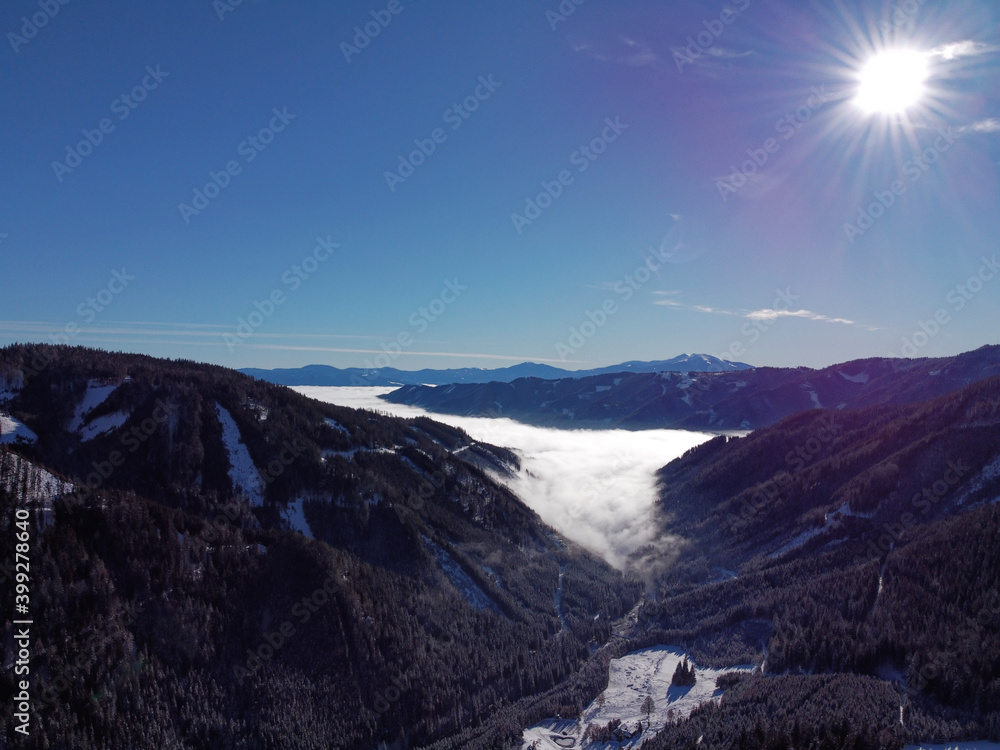 aerial of fog above a valley in the mountains