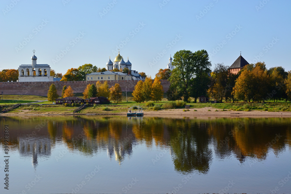Autumn view of the Novgorod Kremlin with reflection in the water of the Volkhov River. Veliky Novgorod. Russia. Saint Sophia Cathedral and belfry Autumn view of the Novgorod Kremlin with reflection in the water of the Volkhov River. Veliky Novgorod. Russia. Saint Sophia Cathedral and belfry