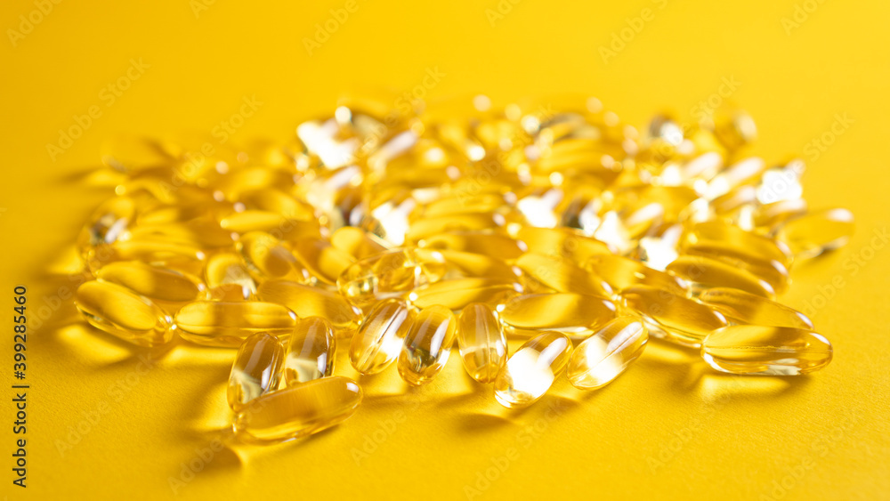 Scattered gel capsules on a yellow background. Close up omega 3 capsules from Fish Oil Scattered gel capsules on a yellow background. Close up omega 3 capsules from Fish Oil