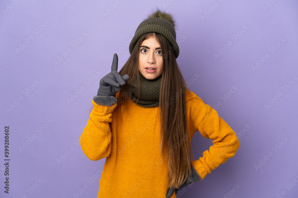 Young caucasian girl with winter hat isolated on purple background thinking an idea pointing the finger up Young caucasian girl with winter hat isolated on purple background thinking an idea pointing the finger up