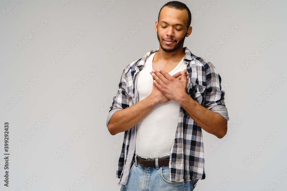 happy pleased african-american man holding hands on chest to heart feeling love appreciation gratitude honesty happy pleased african-american man holding hands on chest to heart feeling love appreciation gratitude honesty