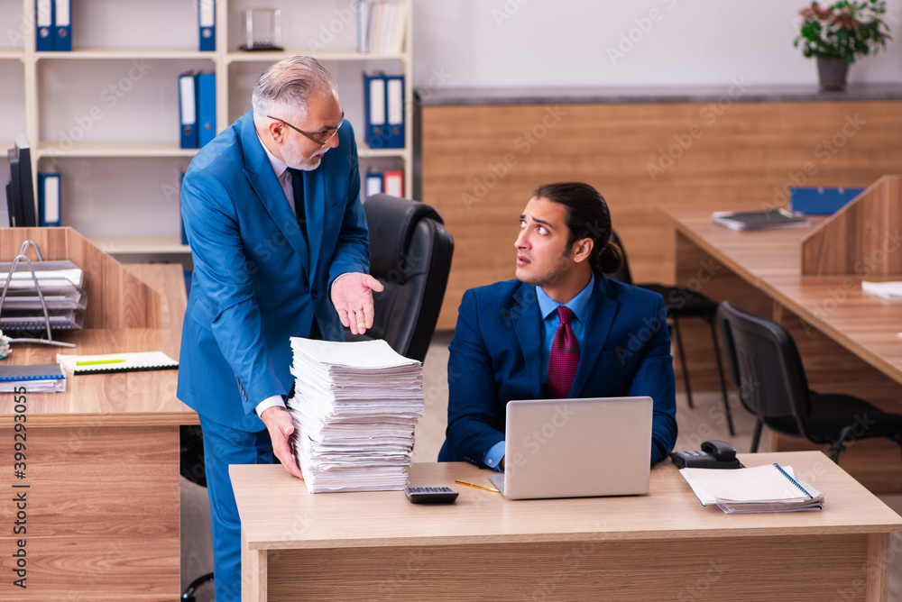 Old male boss and his young male assistant in bullying concept Old male boss and his young male assistant in bullying concept