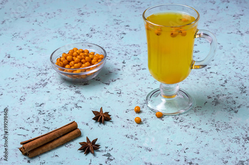 tea with sea buckthorn, cinnamon and anise on a blue background photo