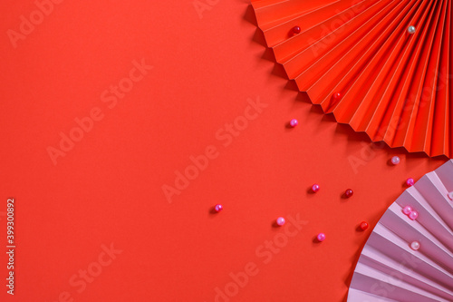 Trendy eco friendly paper fans and beans on the red background. Nice design for greeting card  party invitation or any other purpose. Top view  mock-up photo. Diy concept.