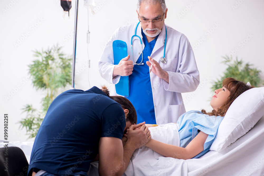Fototapeta premium Young husband visiting sick wife in the clinic