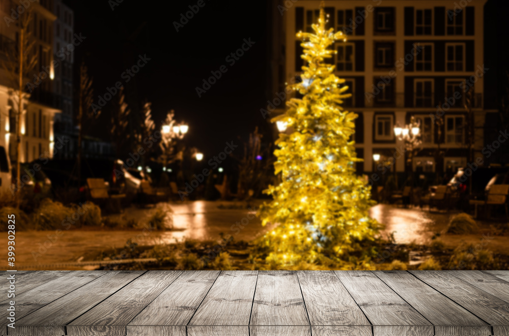 blurred background of xmas tree lights and wall with table of brown color