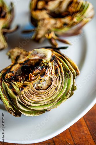 Grilled artichokes. Sautéed organic vegetable in olive oil, herbs, spices and salt and pepper. Classic American steakhouse, restaurant or French bistro side dish.