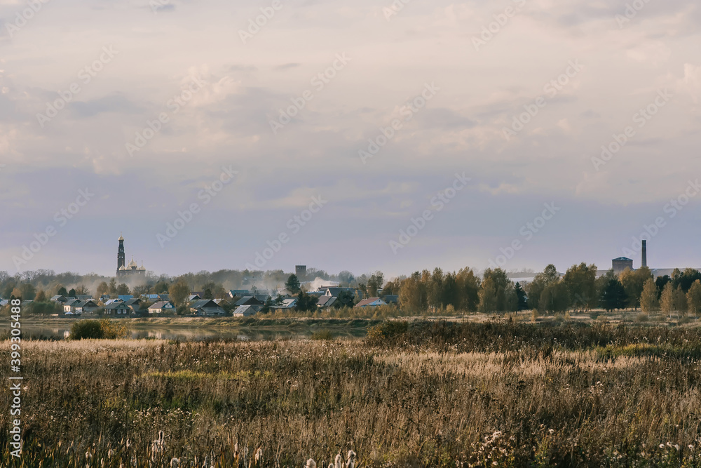 autumn evening landscape with a field and a river and a Christian Church on the horizon autumn evening landscape with a field and a river and a Christian Church on the horizon