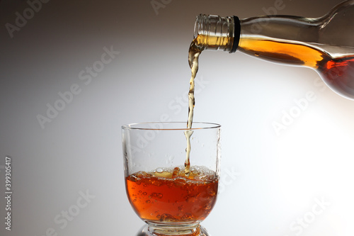Whiskey alcohol being poured into a glass.