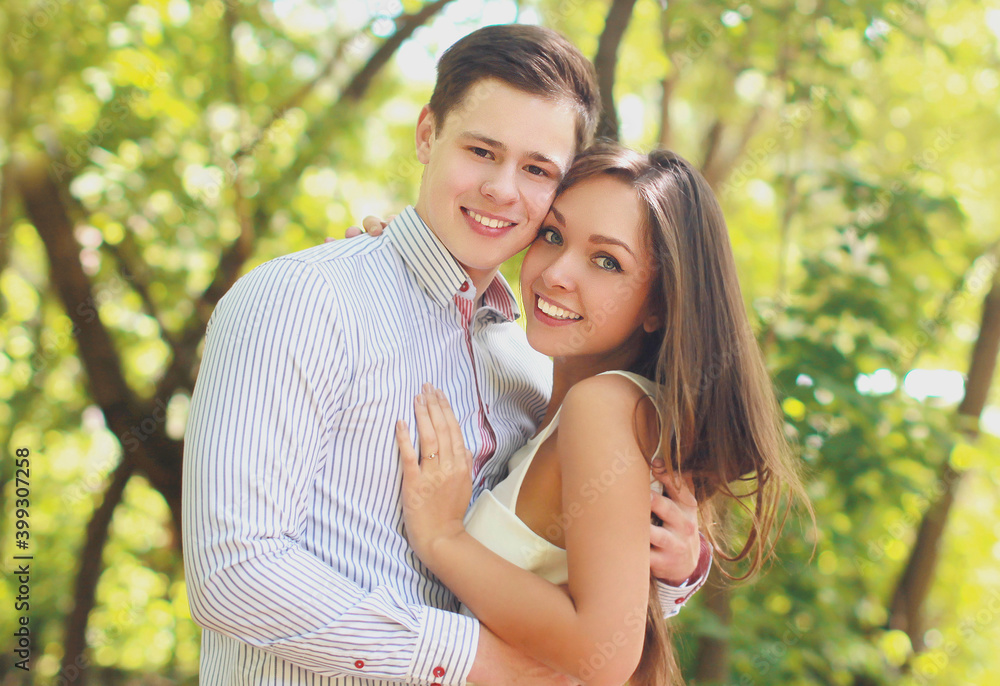 Naklejka premium Portrait of happy smiling young couple together outdoors in sunny park