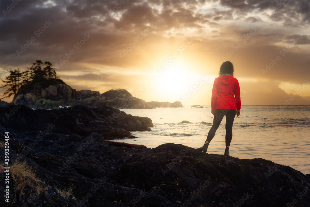 Wild Pacifc Trail, Ucluelet, Vancouver Island, BC, Canada. Adventurous Girl Enjoying the Beautiful View of the Rocky Ocean Coast. Colorful Sunset Sky. Concept: Travel, adventure, freedom