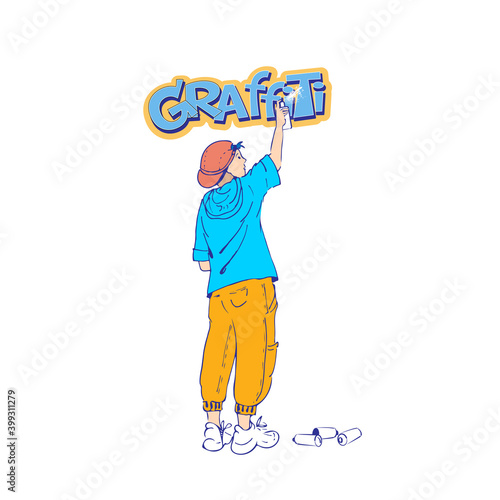 A teenager draws graffiti on the wall.