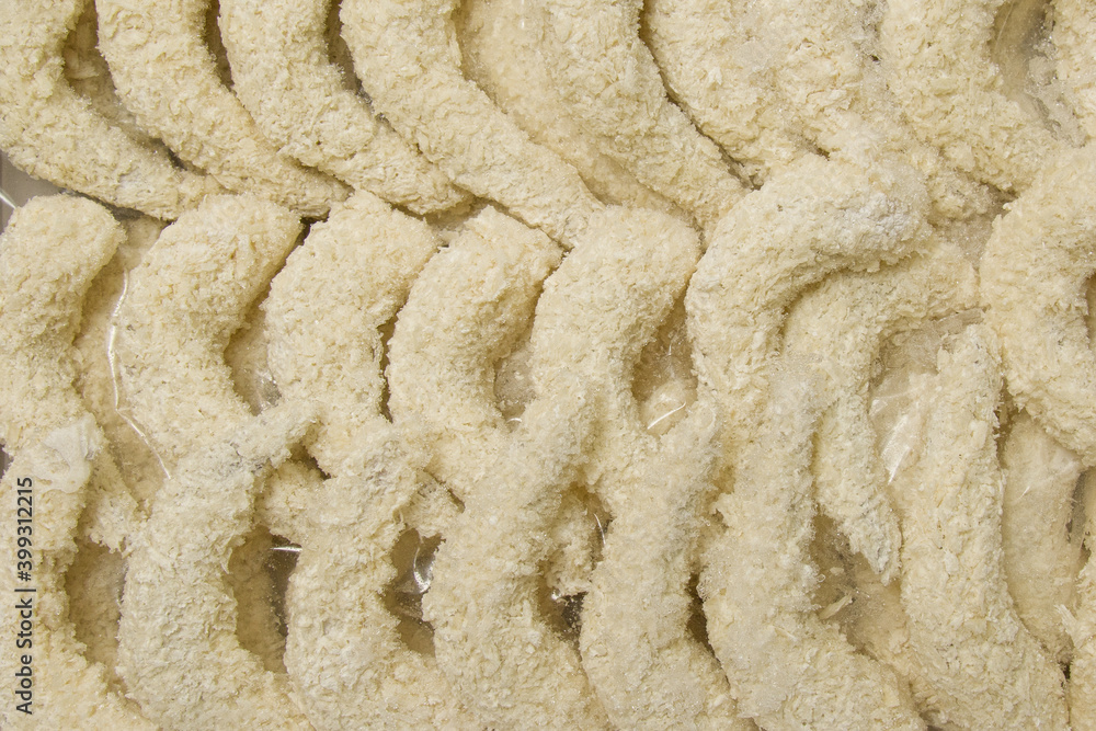 Lots of breaded shrimp ready to cook. A semi-finished dish. Shrimp background in food casing. View from above. Lots of breaded shrimp ready to cook. A semi-finished dish. Shrimp background in food casing. View from above.