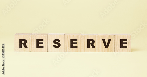 word reserve with small wooden cube on yellow background