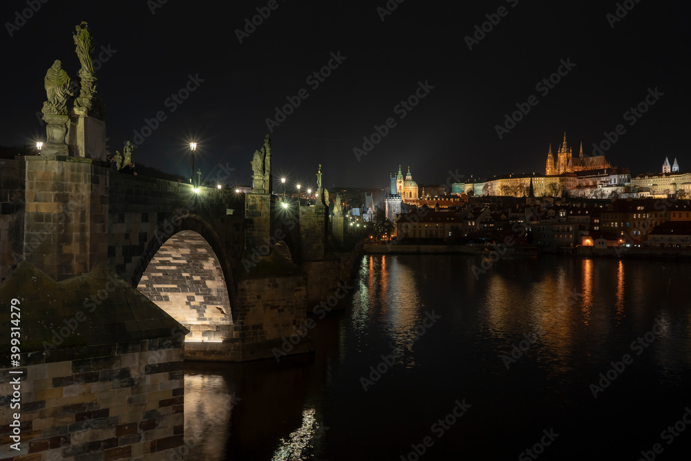 old stone  Charles bridge and lights from street lights and the flowing Vltava river in the center of Prague in the Czech Republic at night