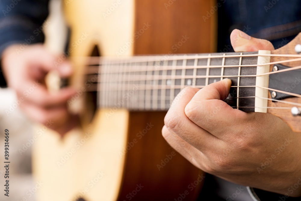 musician playing strum acoustic guitar.