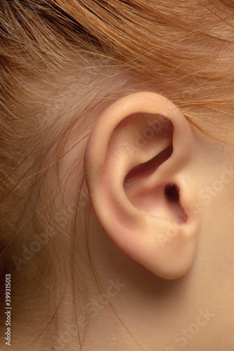 Ear. Close up portrait of beautiful redhair caucasian female model. Parts of face. Beauty, fashion, skincare, cosmetics, wellness concept. Copyspace. Well-kept skin, fresh look, details.