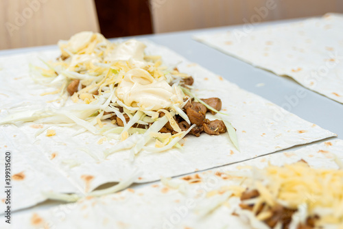 An almost finished and open shawarma lies on the table. photo