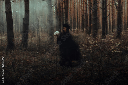 Slika na platnu blurred silhouette of a terrible witch with a skull in her hands performing a my