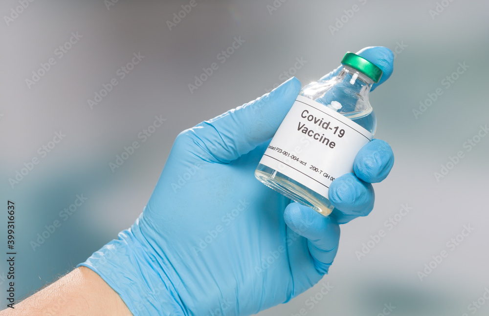 hand in blue gloves presenting a bottle / flask with Covid-19 serum / vaccine hand in blue gloves presenting a bottle / flask with Covid-19 serum / vaccine