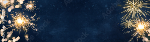 Silvester party New year background banner panorama long- sparklers and bokeh lights on dark blue night sky texture  with space for text 