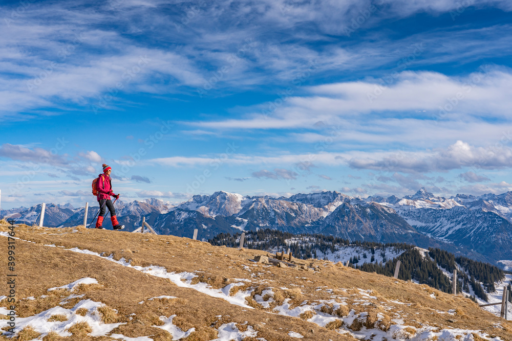 nice and active senior woman snowshoeing in deep powder snow in the Allgau alps, Bavaria, Germany